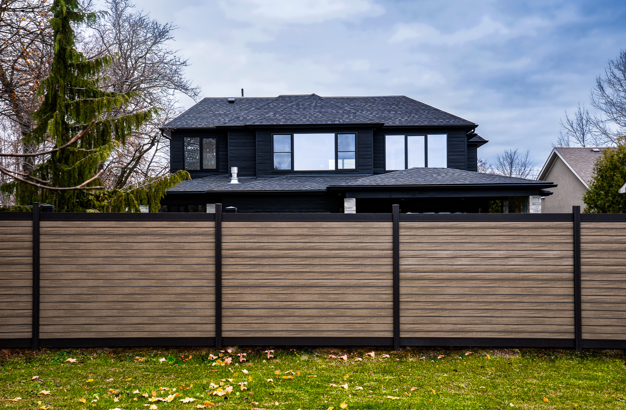 Modern backyard with wood-look aluminum fence from PrimeAlux.