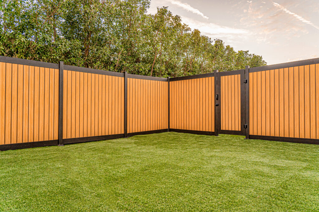 Yellow Aluminum Vertical Fence in privacy plus configuration with grass and trees