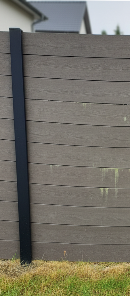 Older composite fence, still standing but visually tired.