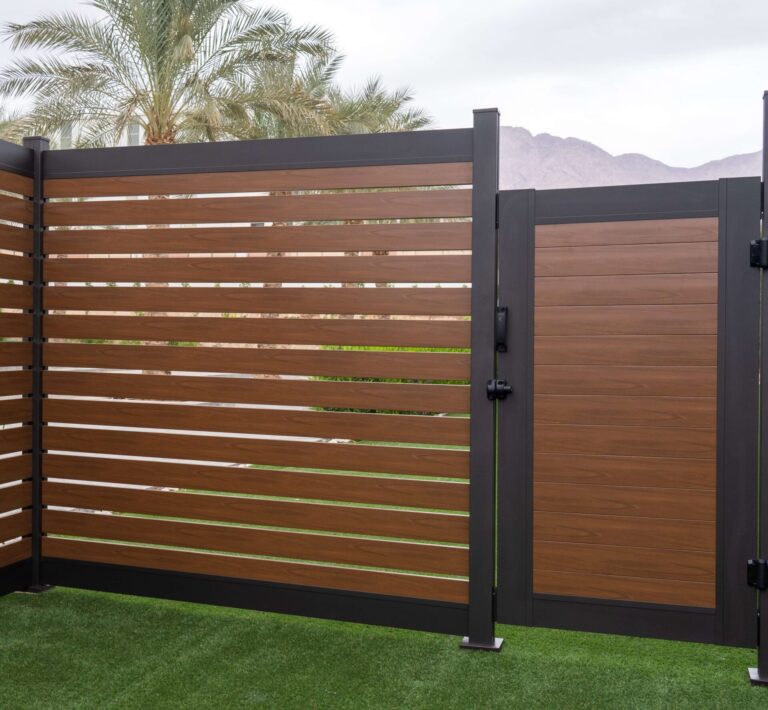 Dark aluminum privacy fence enclosing an outdoor commercial patio seating area